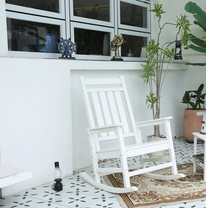 Oversized white wooden rocking chair with slatted back on an outdoor rug beside potted plants on Tampa Home & Garden Store