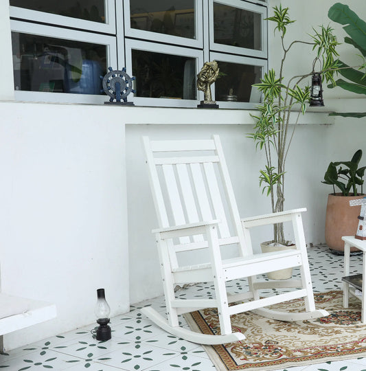 Oversized white wooden rocking chair with slatted back on an outdoor rug beside potted plants on Tampa Home & Garden Store