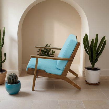 Genuine lounge chair with solid wood frame and light blue cushions in a sunlit arched alcove on Tampa Home & Garden Store
