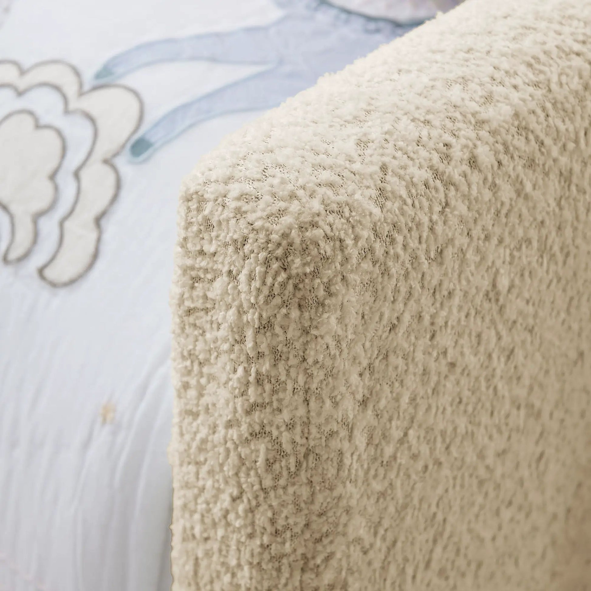 Upholstered platform bed frame close-up in beige plush fabric with textured surface on Tampa Home & Garden Store