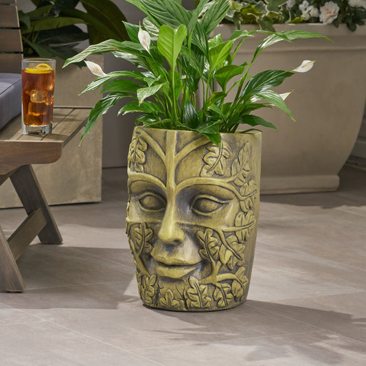 Garden urn planter with carved face, vine detail and weathered gold finish holding green plant on Tampa Home & Garden Store