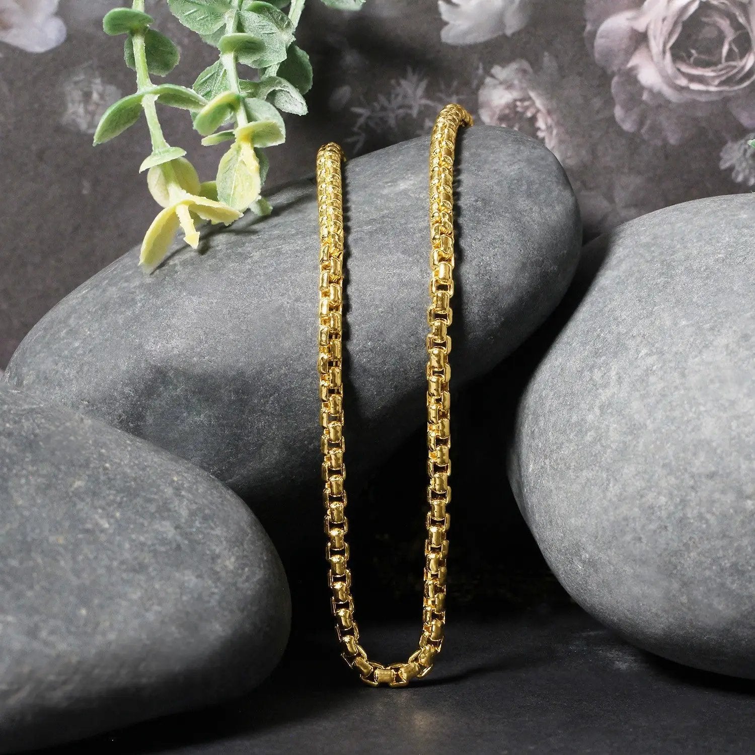 Two 3.4mm 14k yellow gold round box chain necklaces by Bids.com, draped over gray stones on Tampa Home & Garden Store