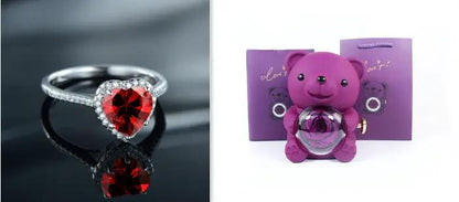 Heart-shaped ruby ring with diamond band beside purple teddy bear rotating jewelry box on Tampa Home & Garden Store