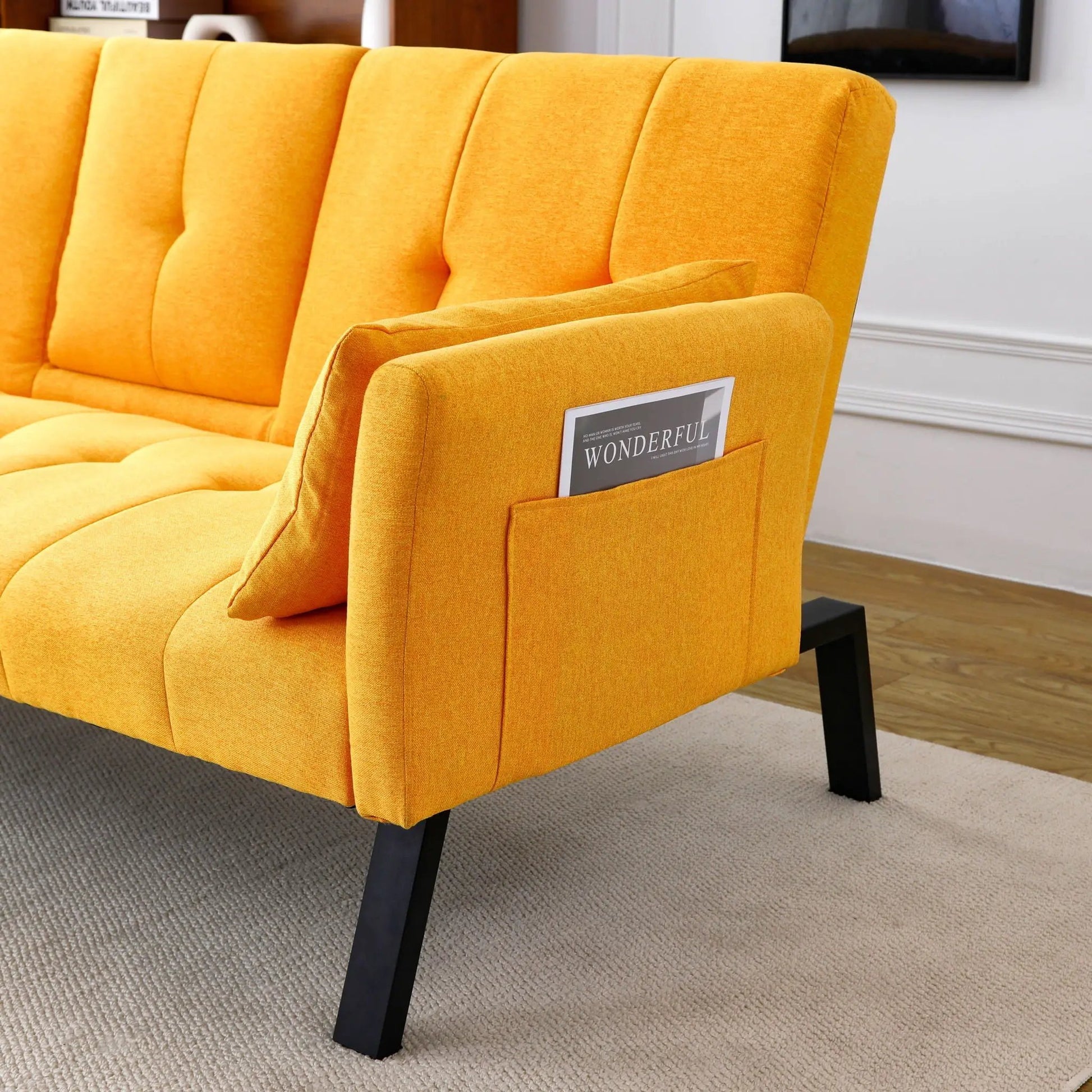 Sofa bed futon in bright orange fabric with tufted back and black metal legs on Tampa Home & Garden Store