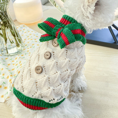 Bowknot hollow-knit dog sweater in cream with wooden buttons and green-red trim bow on a fluffy white dog on Tampa Home & Garden Store