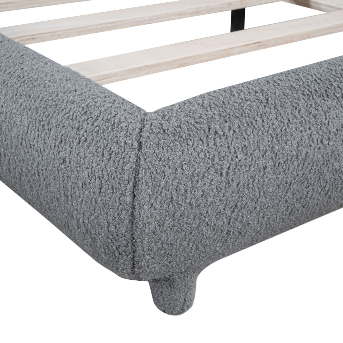 Upholstered platform bed with thick light-wood slat frame and curved foot, shown on shag rug on Tampa Home & Garden Store