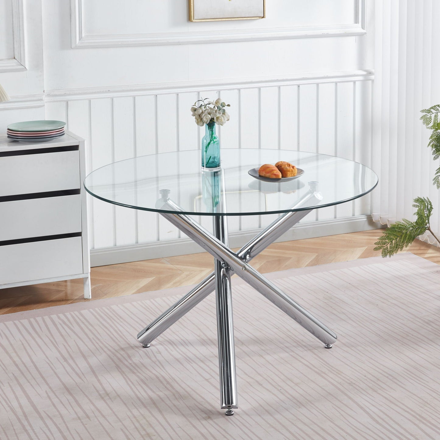 Dining Table round glass top with chrome cross legs in a white dining space, turquoise vase on Tampa Home & Garden Store