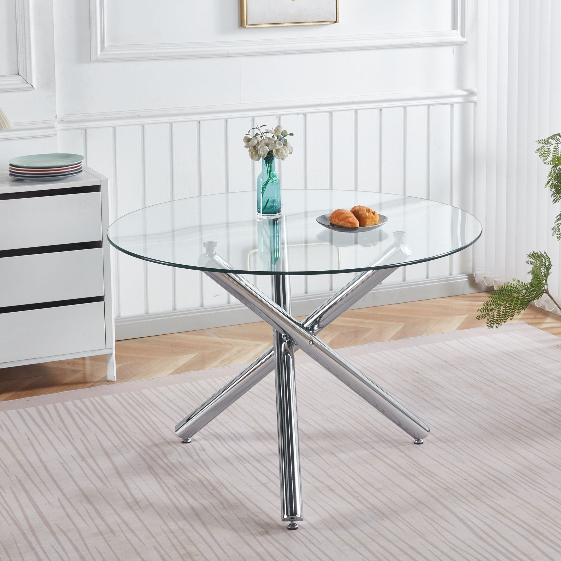 Dining Table round glass top with chrome cross legs in a white dining space, turquoise vase on Tampa Home & Garden Store