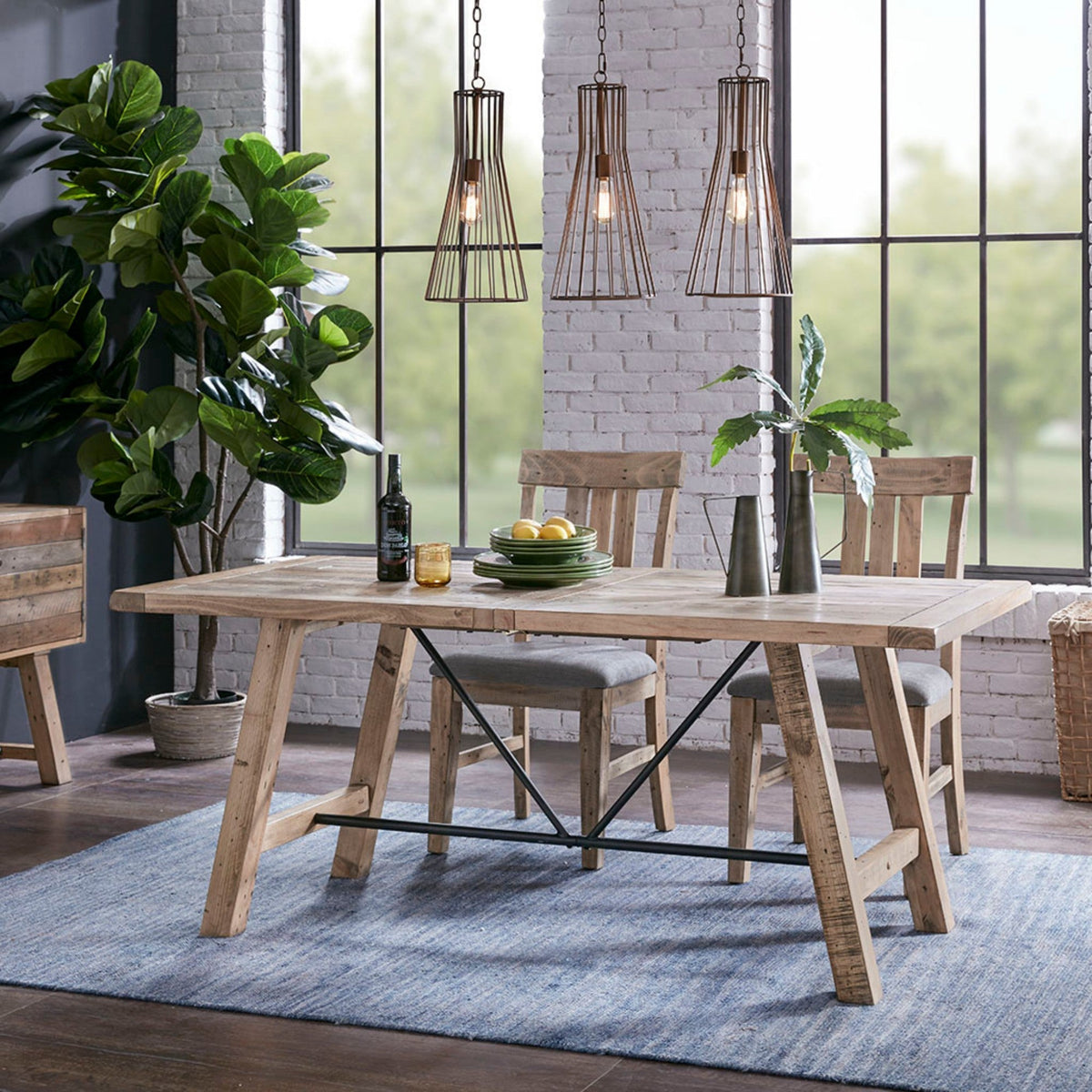 Rustic dining table with natural pine finish and metal support, industrial trestle legs on Tampa Home & Garden Store