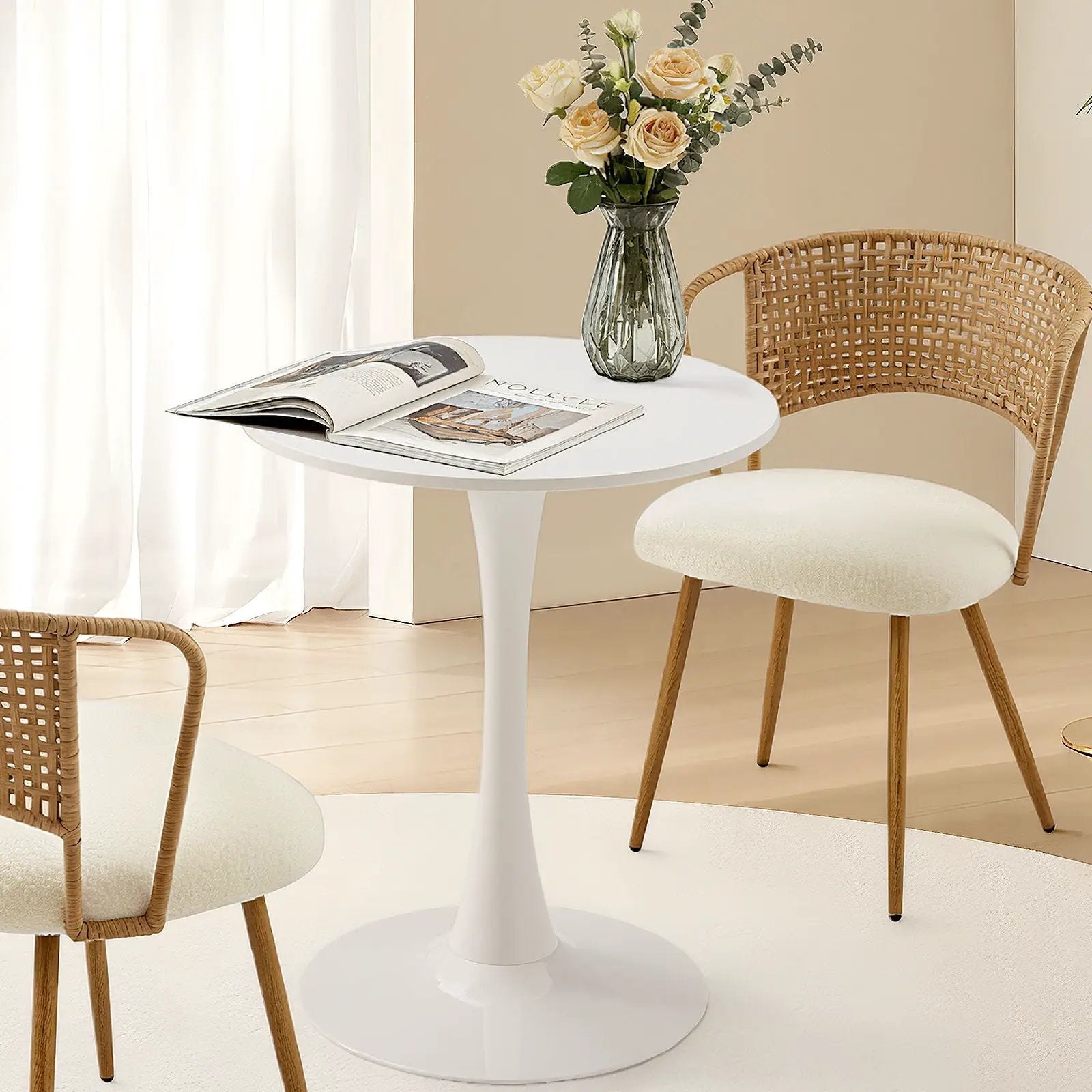 Round tulip-base white pedestal dining table with wicker chairs and pale yellow rose vase on Tampa Home & Garden Store