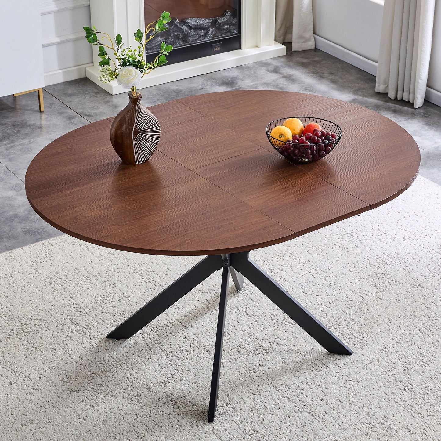 Extendable round dining table in walnut finish with a black metal base and visible leaf seam on Tampa Home & Garden Store