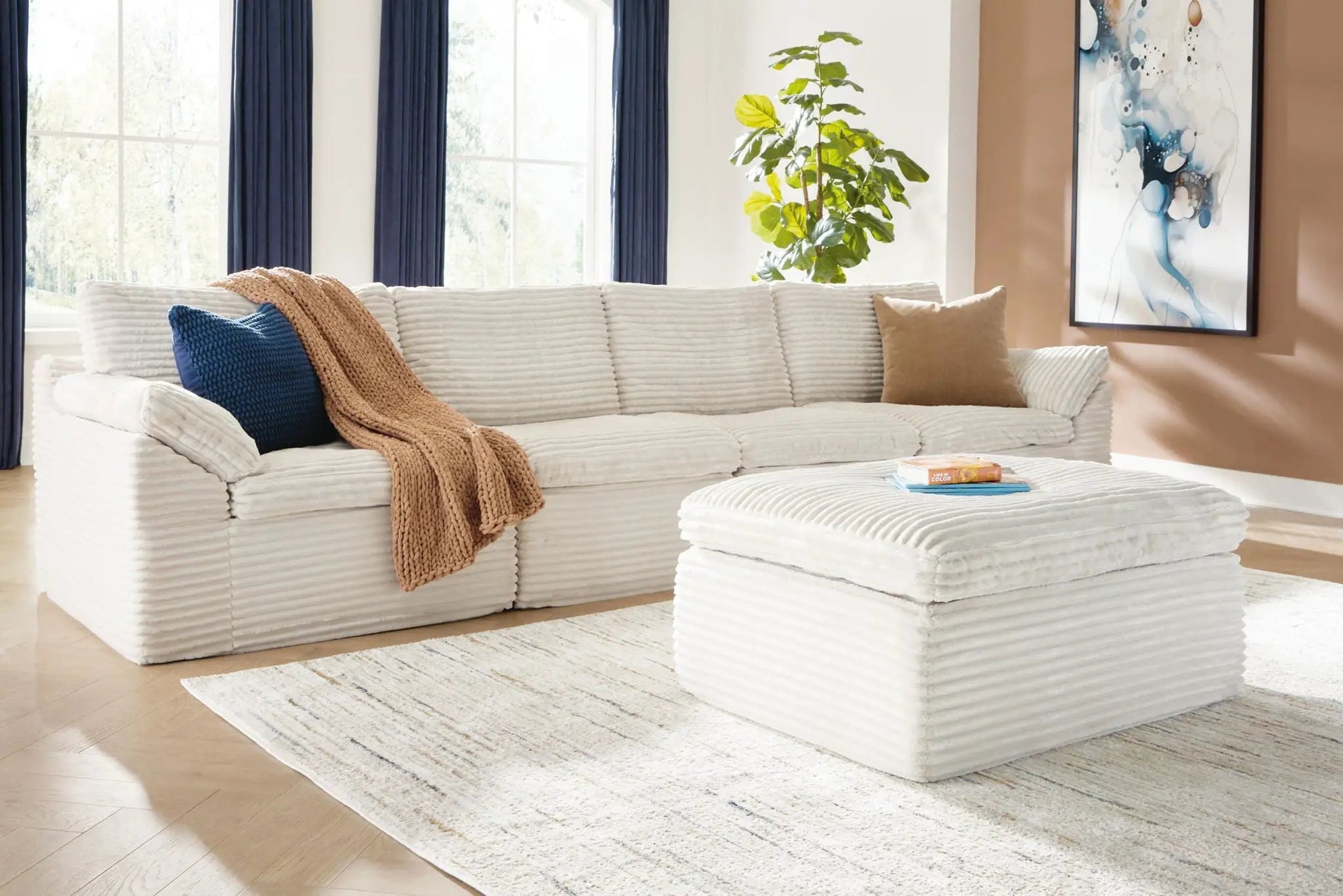 Fannin ivory 4-piece stationary sectional with ottoman in ribbed fabric, navy pillow on Tampa Home & Garden Store