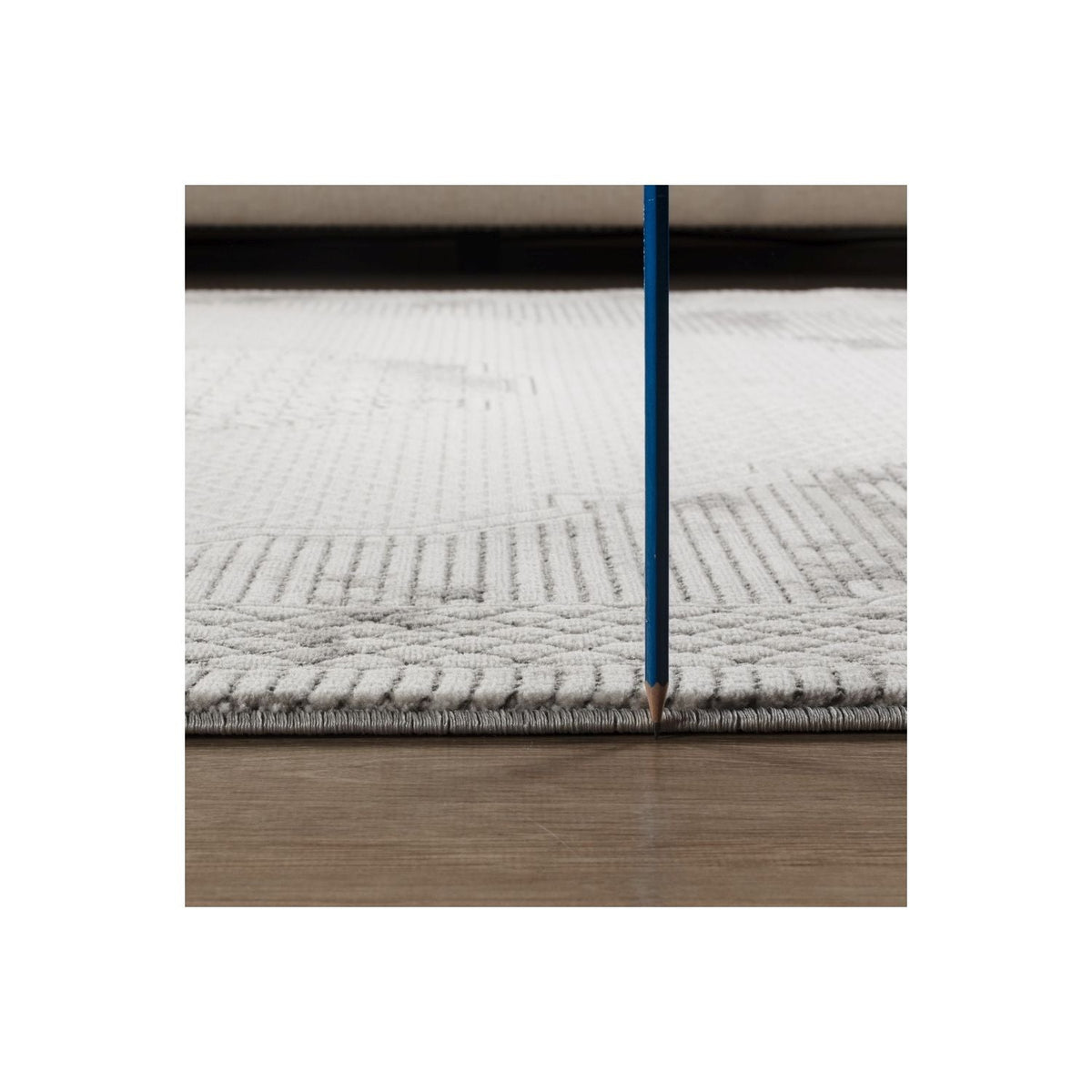 Area rug gray medallion with geometric 3D texture, edge visible, blue pencil for scale on Tampa Home & Garden Store