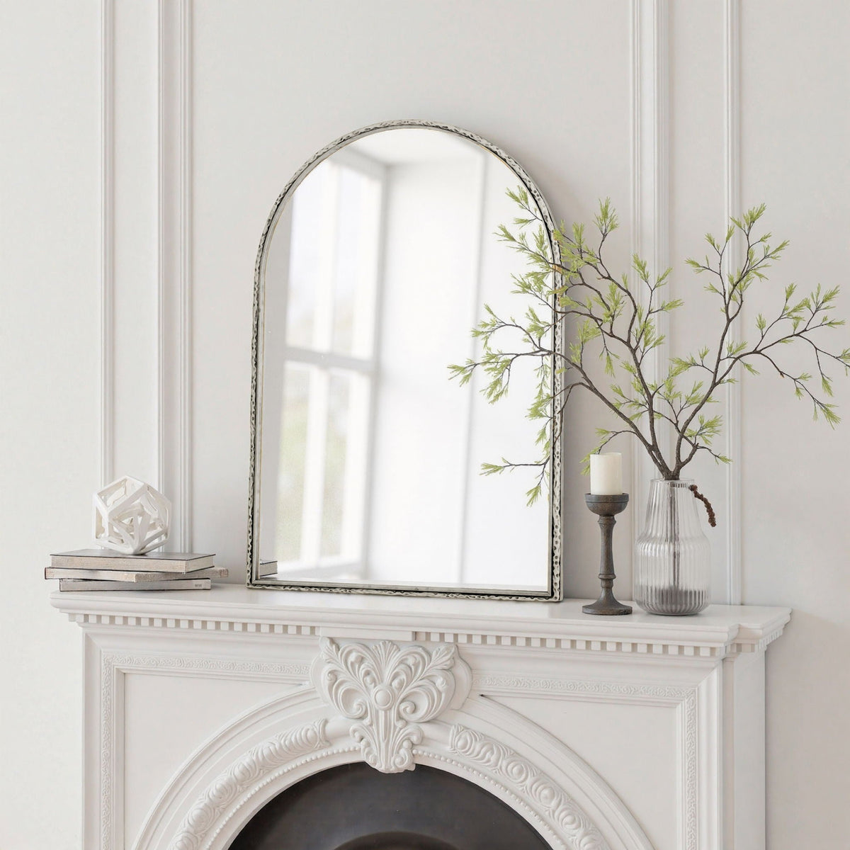 Arched silver-tone wall mirror with shatterproof glass on a white mantel beside books on Tampa Home & Garden Store