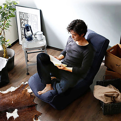 Reclining Japanese chair Lazy Sofa in black upholstery with a man seated in a living room on Tampa Home & Garden Store