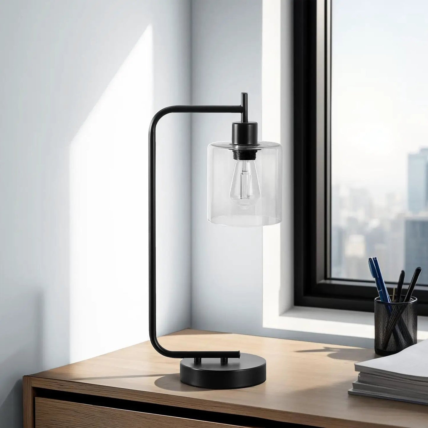 Table lamp with black metal frame and clear glass shade on a desk near a window on Tampa Home & Garden Store