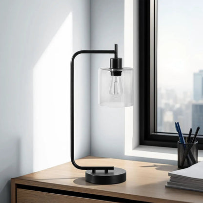 Table lamp with black metal frame and clear glass shade on a desk near a window on Tampa Home & Garden Store