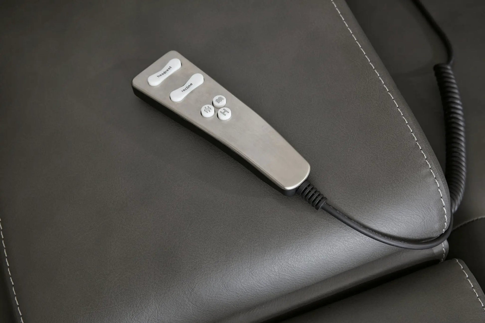 Pittson power reclining sectional remote on gray leather upholstery with white stitching on Tampa Home & Garden Store