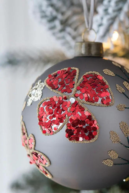 Glass Christmas ornament ball with red clover shapes outlined in gold beads on gray matte on Tampa Home & Garden Store