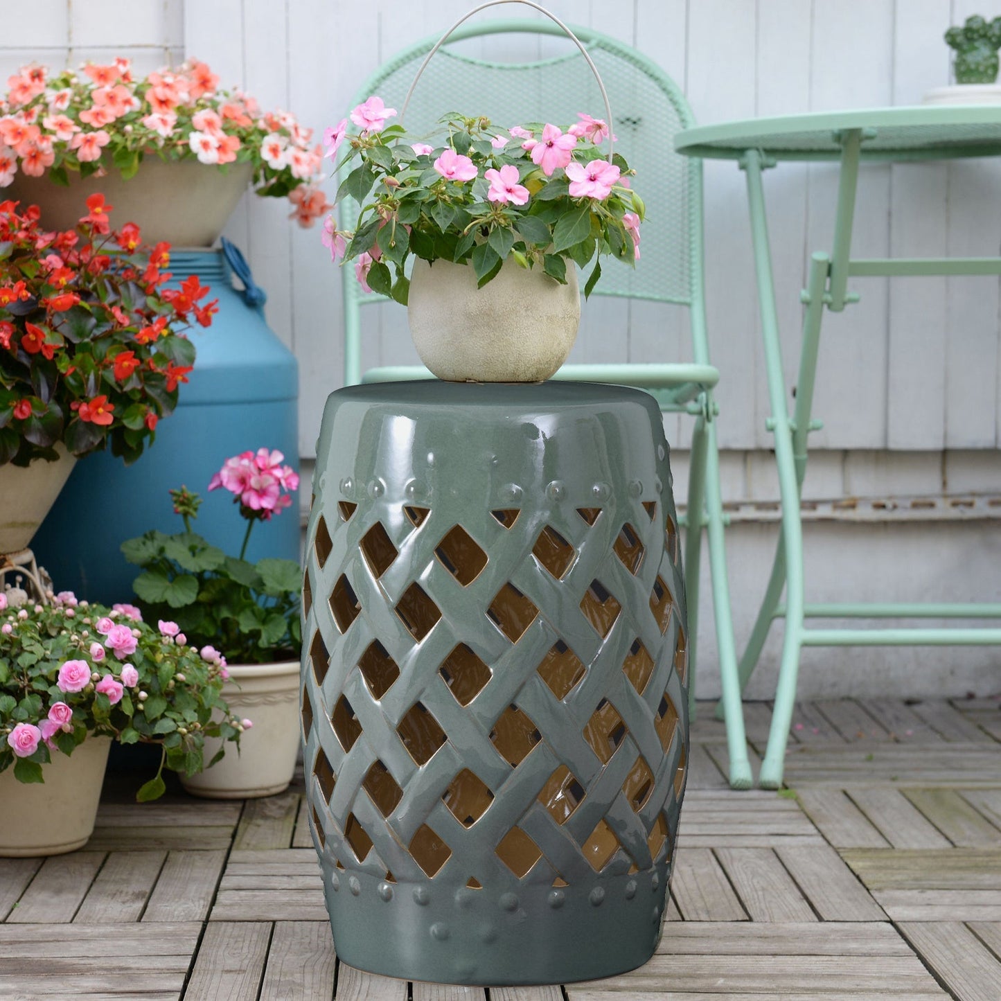 Ceramic garden stool with woven lattice cutouts in blue-green glaze topped by beige planter on Tampa Home & Garden Store
