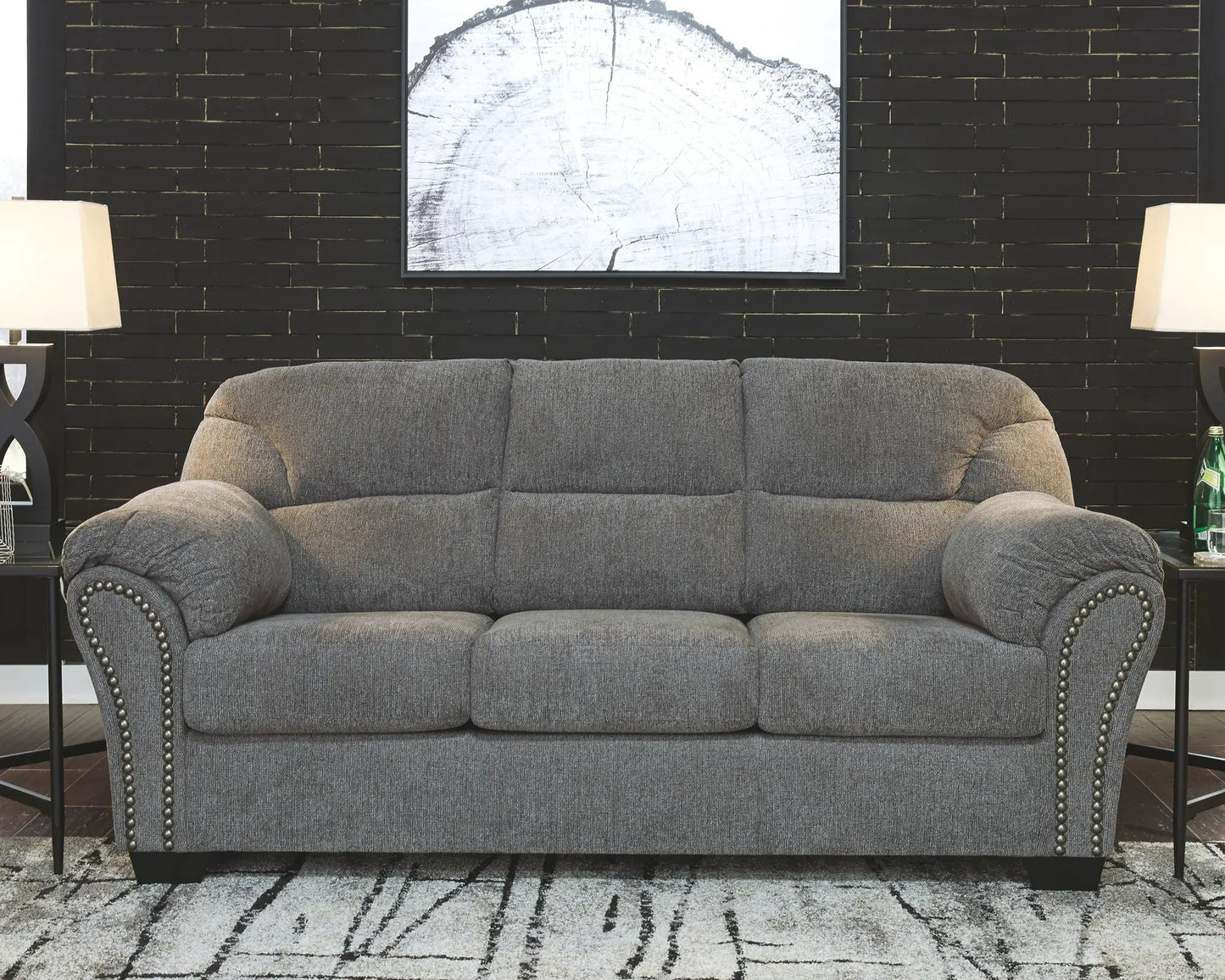 Allmaxx Living Room Set gray stationary sofa with nailhead trim against a black brick wall on Tampa Home & Garden Store