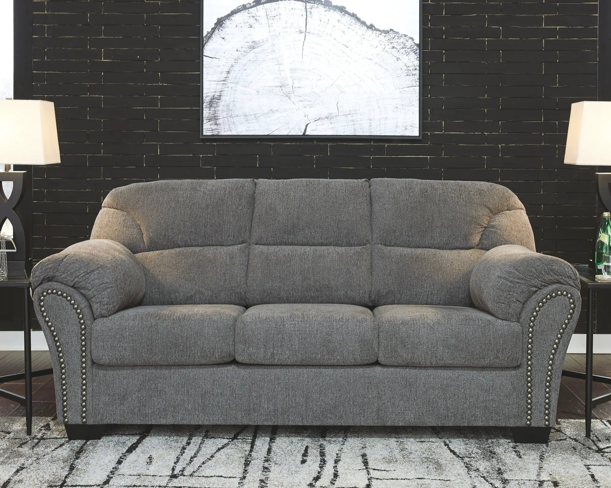 Allmaxx Living Room Set gray stationary sofa with nailhead trim against a black brick wall on Tampa Home & Garden Store