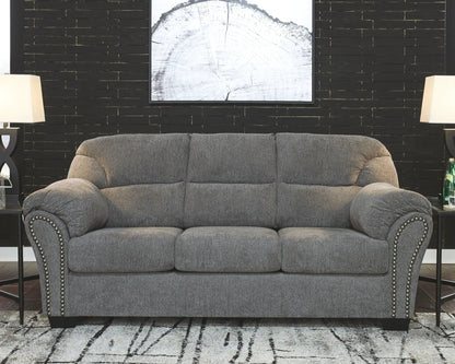 Allmaxx Living Room Set gray stationary sofa with nailhead trim against a black brick wall on Tampa Home & Garden Store