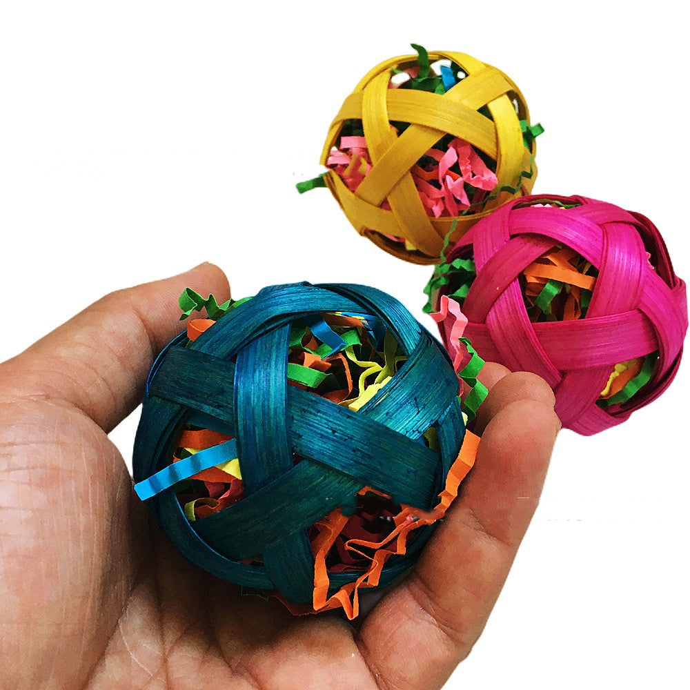Natural bamboo woven toy ball foraging bird toy, blue teal, yellow and pink, three balls in hand on Tampa Home & Garden Store