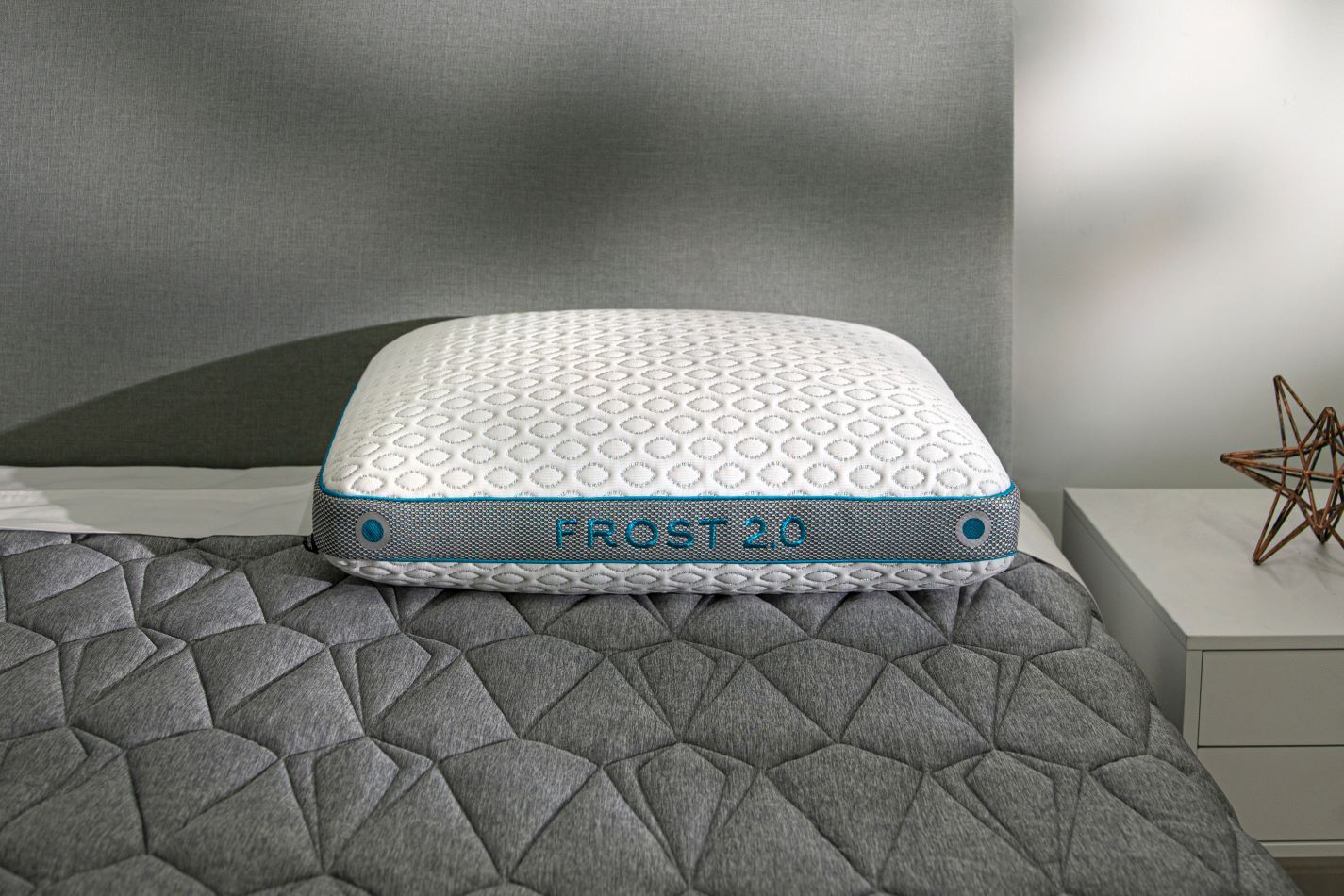 BedGear Frost Performance Pillow 2.0 cooling pillow on gray quilted bed with blue piping on Tampa Home & Garden Store