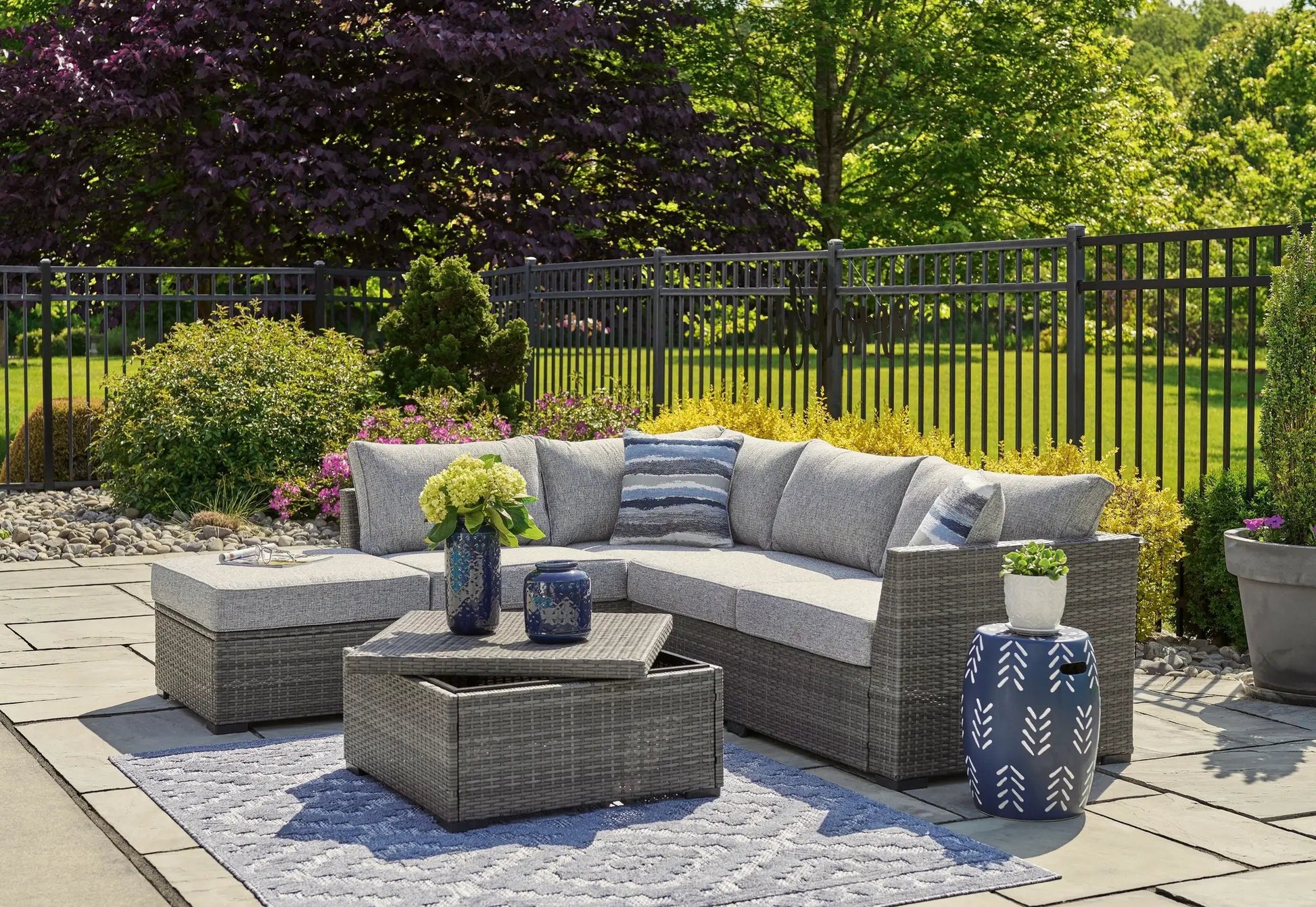 Petal Road gray 4-piece wicker set with loveseat sectional, ottoman, and table on a patio on Tampa Home & Garden Store