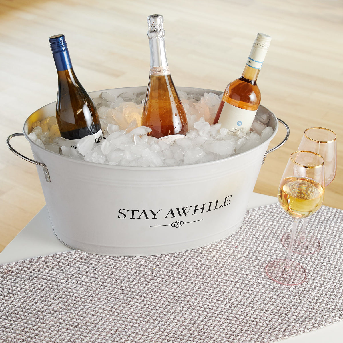 Stay Awhile metal ice bucket in silver, filled with ice and three Twine Living wine bottles on Tampa Home & Garden Store