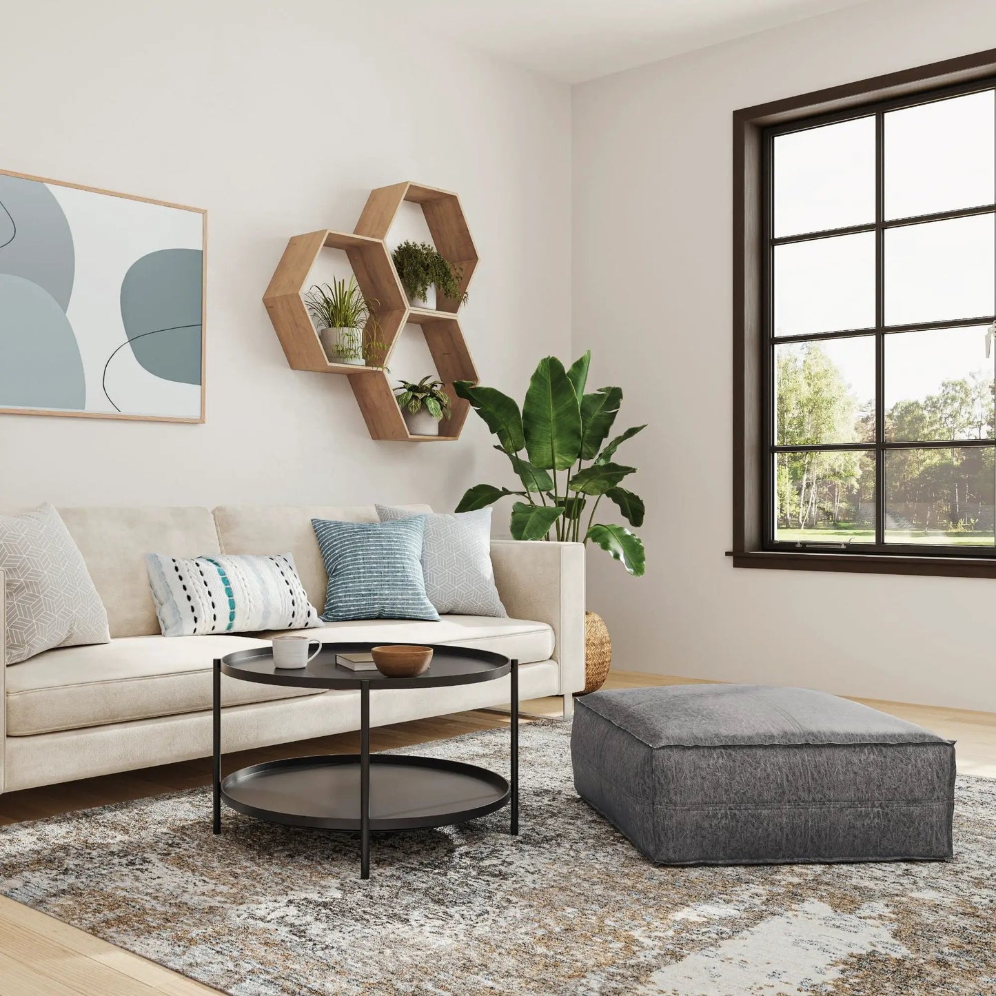 Brody Large Square Coffee Table Pouf in gray fabric, paired with a round black coffee table on Tampa Home & Garden Store
