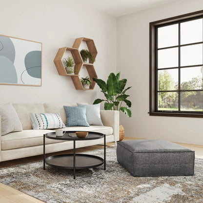 Brody Large Square Coffee Table Pouf in gray fabric, paired with a round black coffee table on Tampa Home & Garden Store