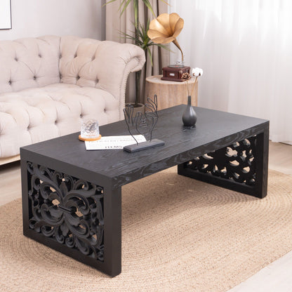 Rustic carved black wood coffee table with ornate side scrollwork in living room on Tampa Home & Garden Store