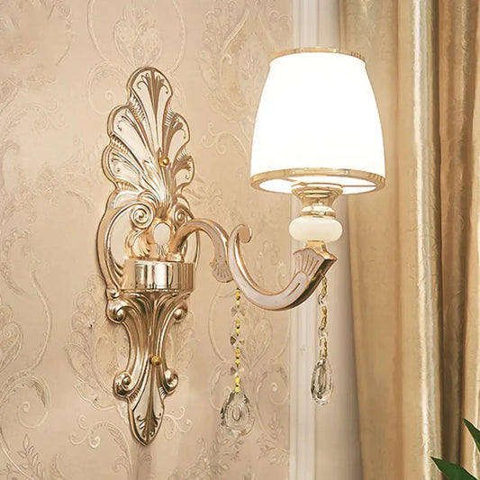 Elegant gold scroll-arm wall sconce with crystal drops and white shade for bedroom on Tampa Home & Garden Store