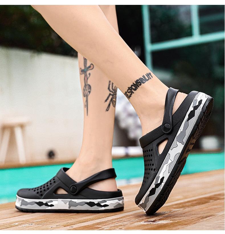 Men's black Stevvex garden clogs with adjustable strap and perforated upper, camo-pattern sole pair shown on deck on Tampa Home & Garden Store