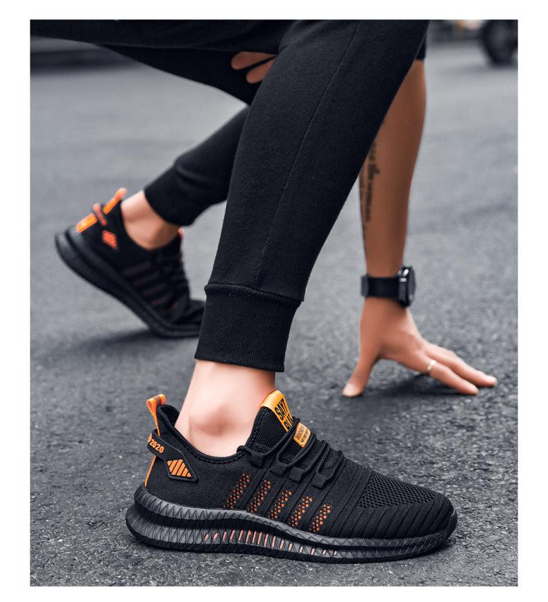 Stevvex men's running sneakers pair, black with orange accents, breathable mesh upper on Tampa Home & Garden Store
