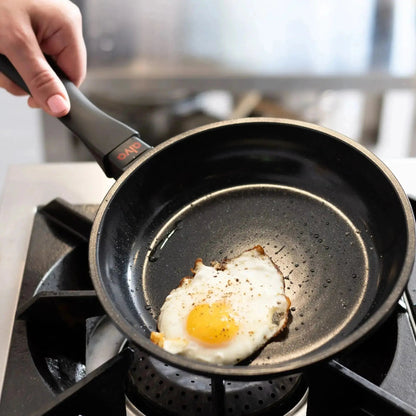 Ceramic Nonstick Frying Pan by Alva Cookware with black handle, sunny-side eggs cooking on Tampa Home & Garden Store