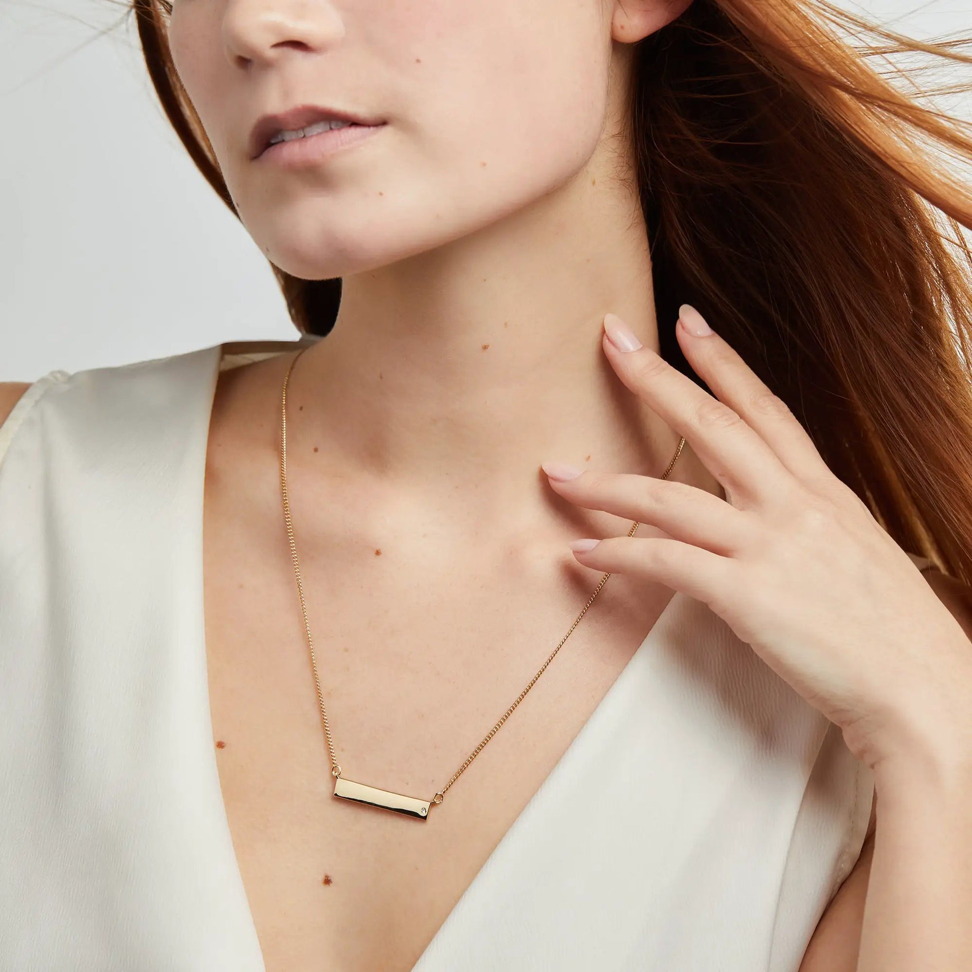 Bar Necklace with Crystal Accent, gold-tone rectangular pendant on delicate chain worn by model on Tampa Home & Garden Store