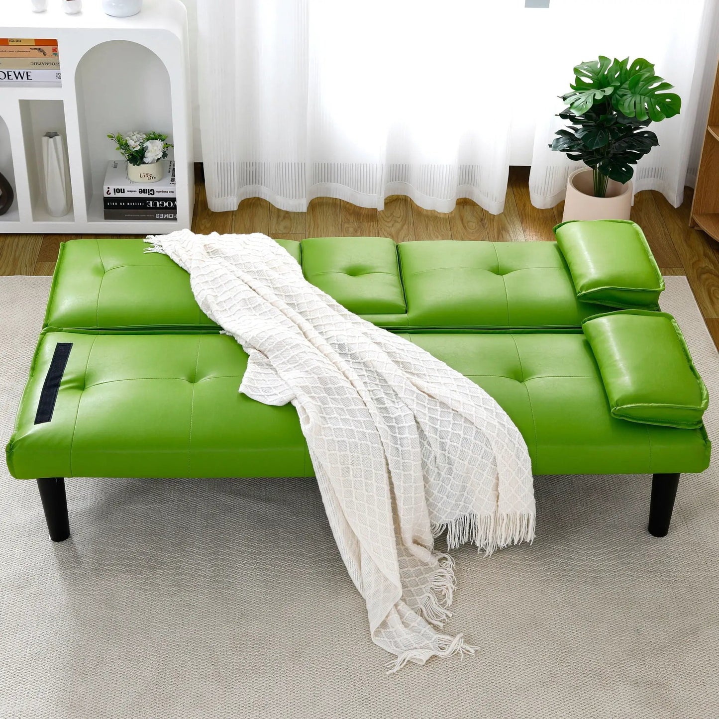 Green leather futon sofa bed with tufted cushions in a bright living room on Tampa Home & Garden Store