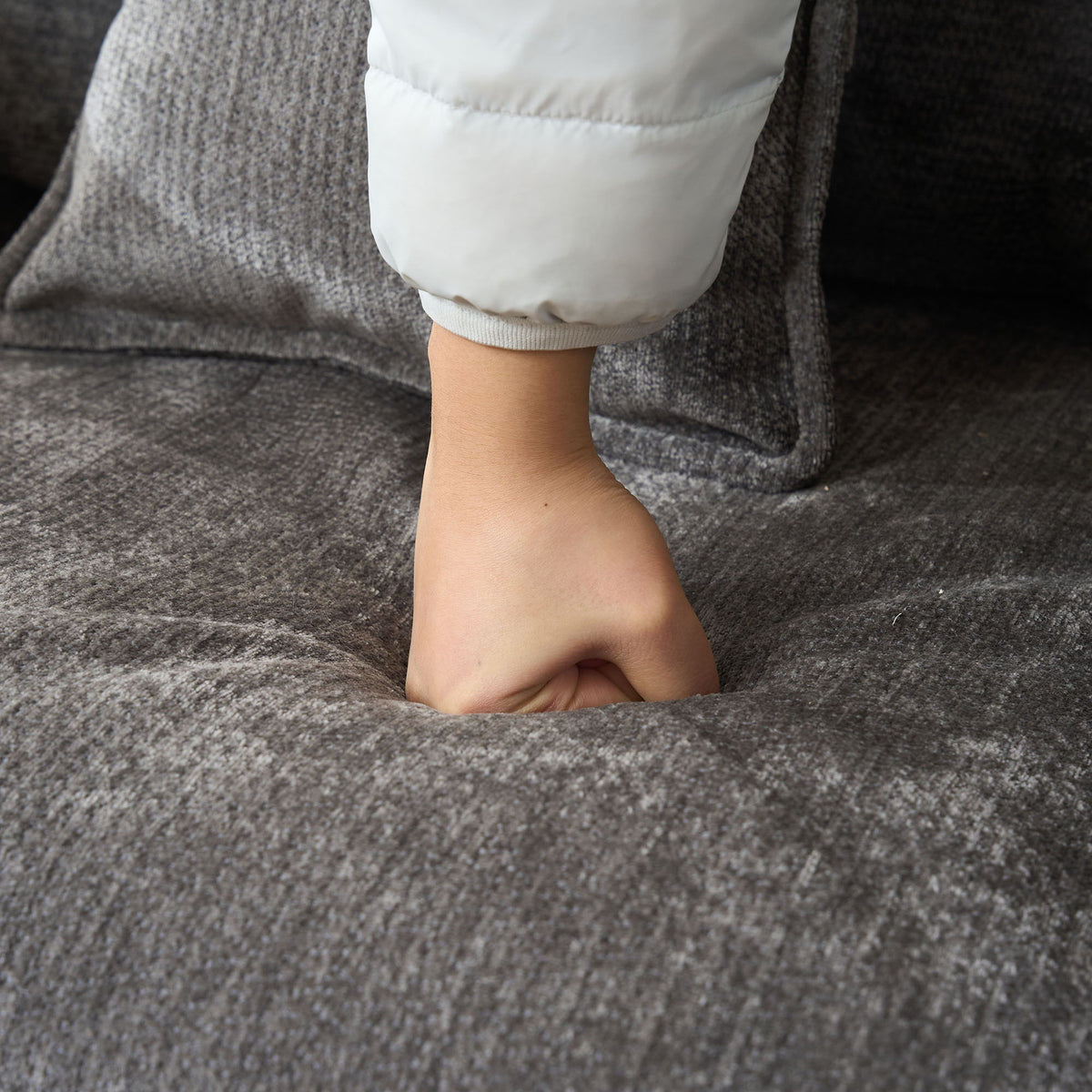 Modern Reading Armchair closeup: white puffer sleeve against gray textured upholstery on Tampa Home & Garden Store