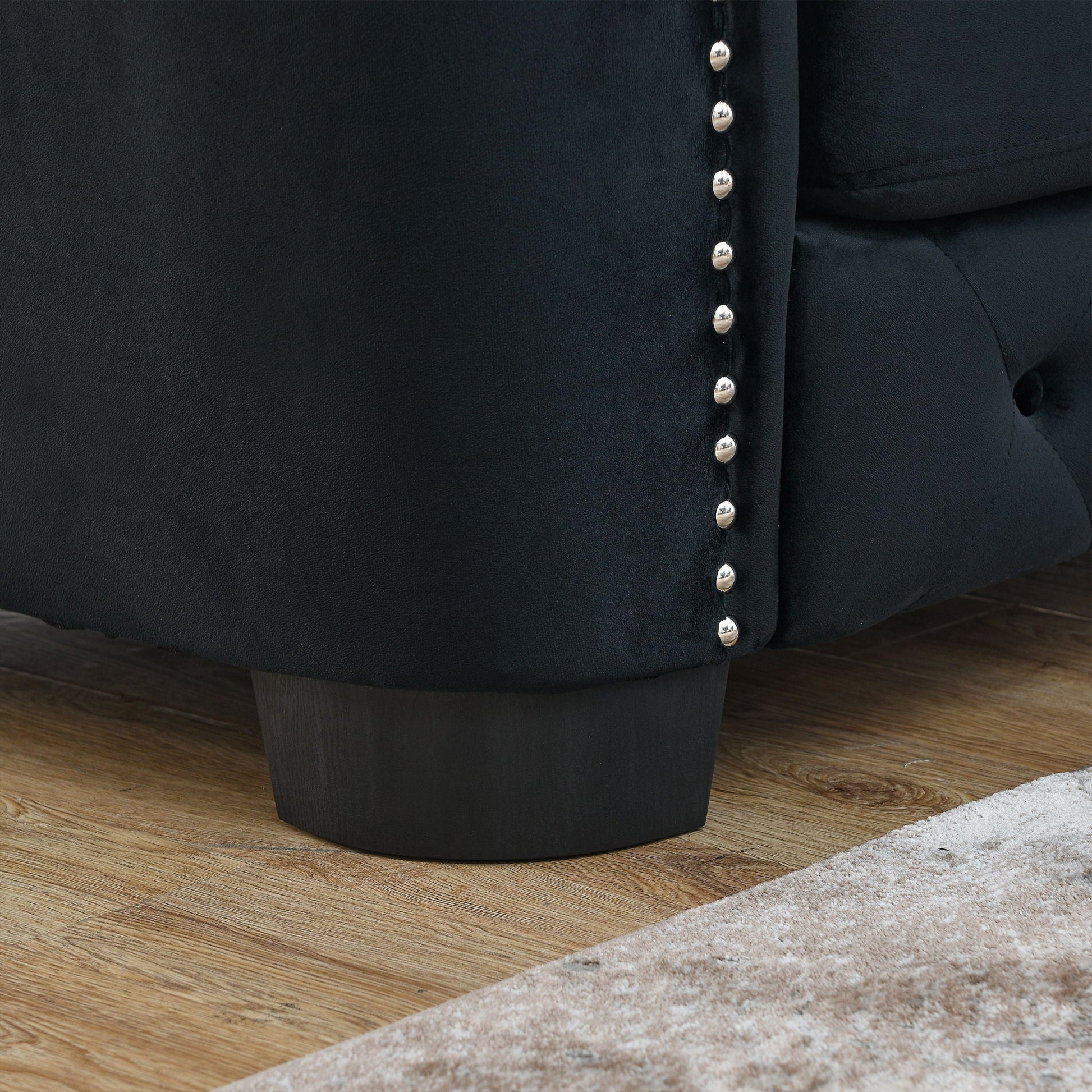 Modern Chesterfield sofa in black fabric with tufted back and silver stud trim, stationary on Tampa Home & Garden Store