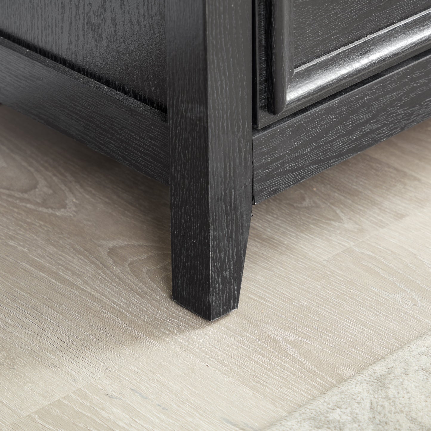 Modern 5-drawer black dresser closeup showing textured wood grain and drawer edge on Tampa Home & Garden Store