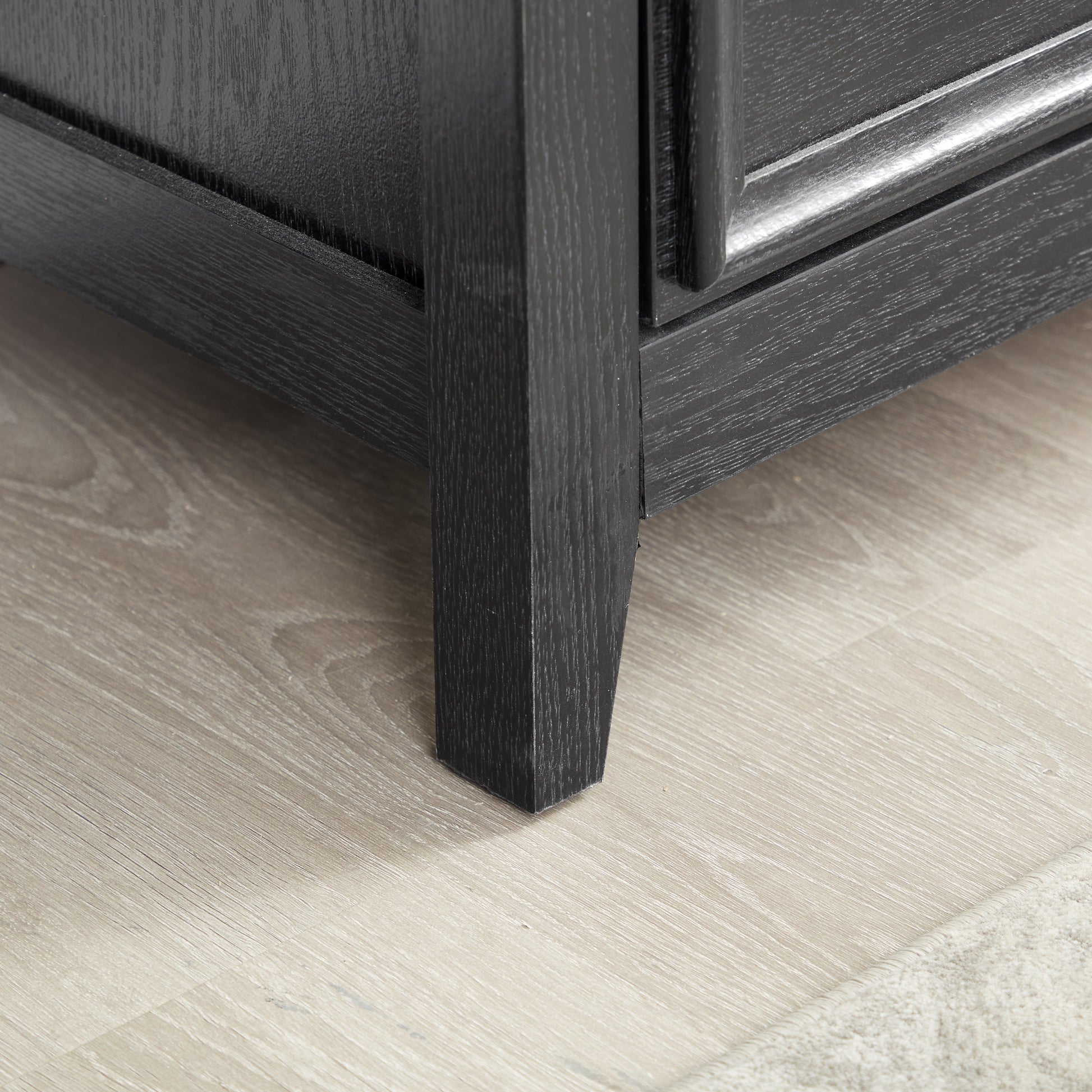Modern 5-drawer black dresser closeup showing textured wood grain and drawer edge on Tampa Home & Garden Store