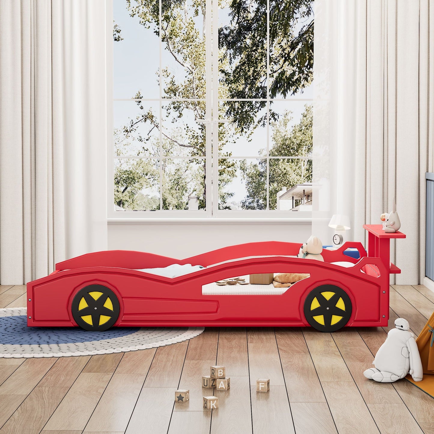 Red race car platform bed with yellow wheels in a kid's room with blocks nearby on Tampa Home & Garden Store