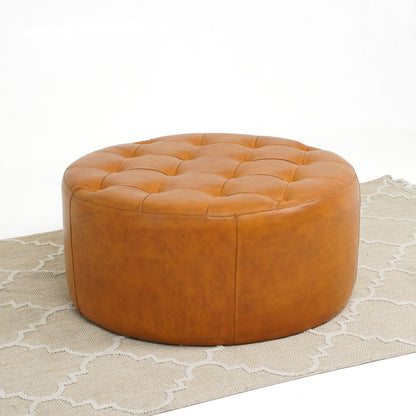 Light tan leather round tufted ottoman with stitched panels and solid wood base on Tampa Home & Garden Store