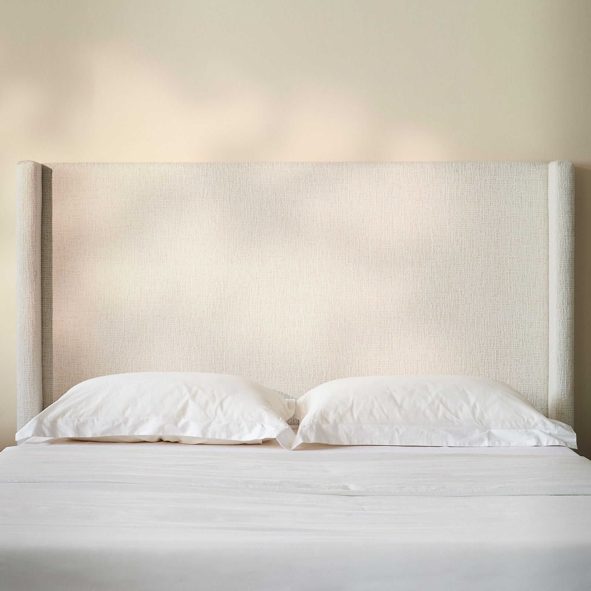 Hosford minimalist upholstered wingback bed with wood base platform beige fabric pillows on Tampa Home & Garden Store