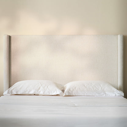 Hosford minimalist upholstered wingback bed with wood base platform beige fabric pillows on Tampa Home & Garden Store