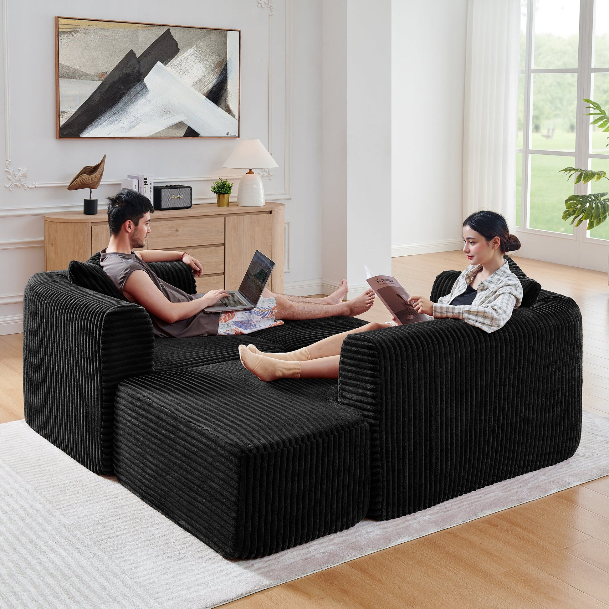 114-inch Cloud Sectional Couch with L-Shape Chaise in black ribbed fabric, two people lounging on Tampa Home & Garden Store