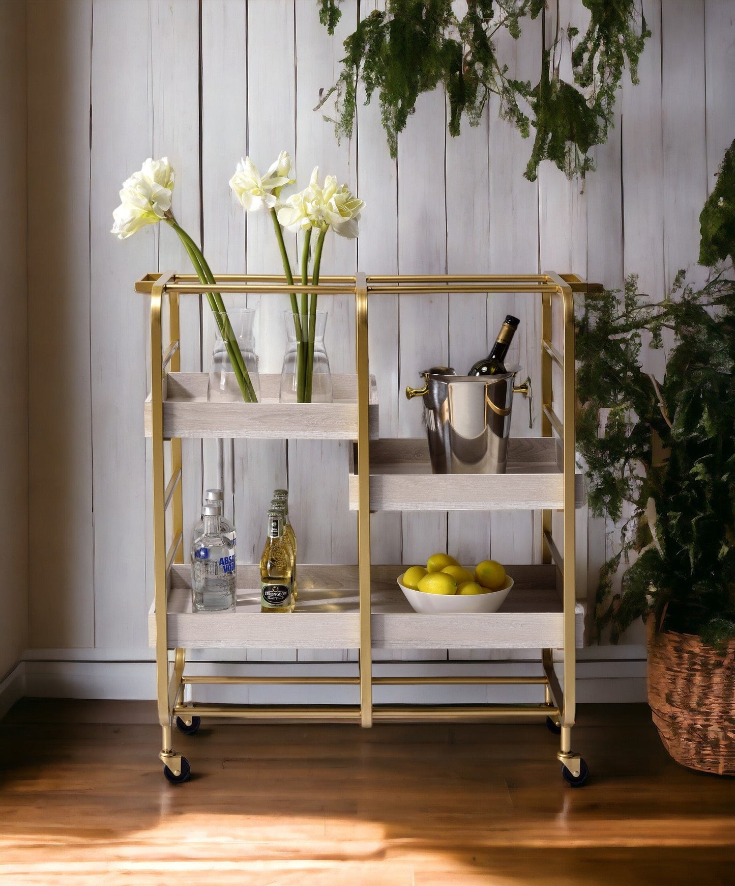 Vorrik gold and white washed serving cart with brass frame, two shelves, bottles and lemons on Tampa Home & Garden Store